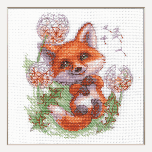 A completed cross-stitch of a smiling red fox lying among dandelion puffs, with seeds floating away, stitched in bright orange, green, and soft lavender tones on white Aida fabric.