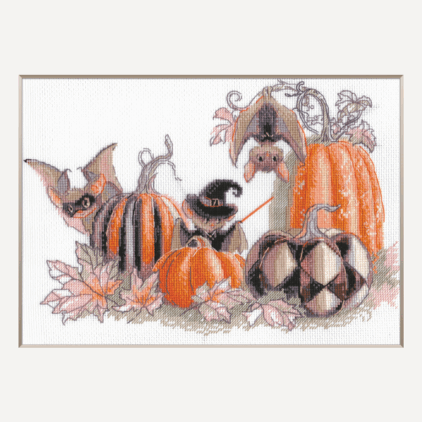 A completed cross-stitch of bats and pumpkins in a Halloween theme, with striped and checkered pumpkins, autumn leaves, and a bat in a witch hat holding a wand.
