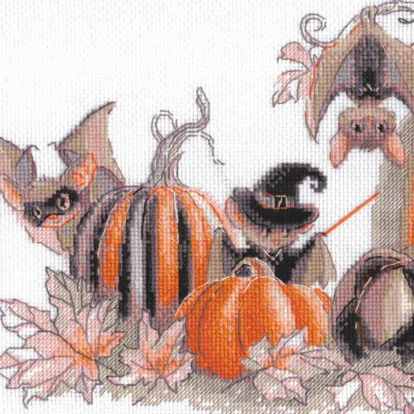 A completed cross-stitch of bats and pumpkins in a Halloween theme, with striped and checkered pumpkins, autumn leaves, and a bat in a witch hat holding a wand.