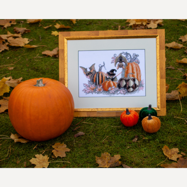 A completed cross-stitch of bats and pumpkins in a Halloween theme, with striped and checkered pumpkins, autumn leaves, and a bat in a witch hat holding a wand.