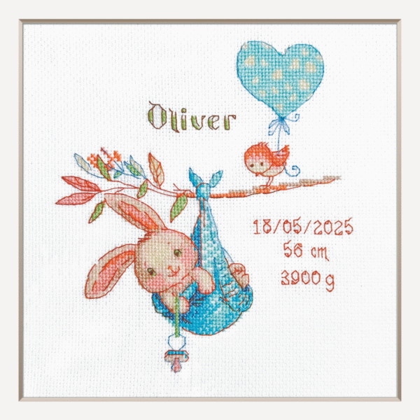 A completed cross-stitch birth sampler featuring a bunny in a blue sling hanging from a branch, with a bird holding a blue heart balloon and space for baby details.