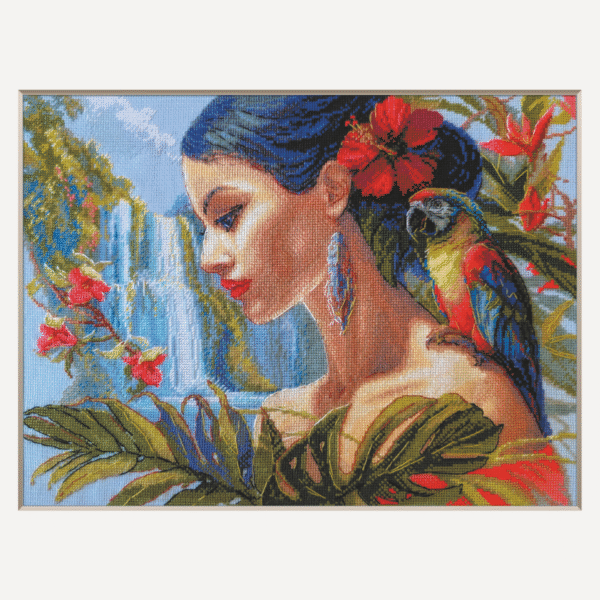 A completed cross-stitch of a woman with red hibiscus flowers in her hair, a colorful parrot on her shoulder, tropical leaves in the foreground, and waterfalls in the background.