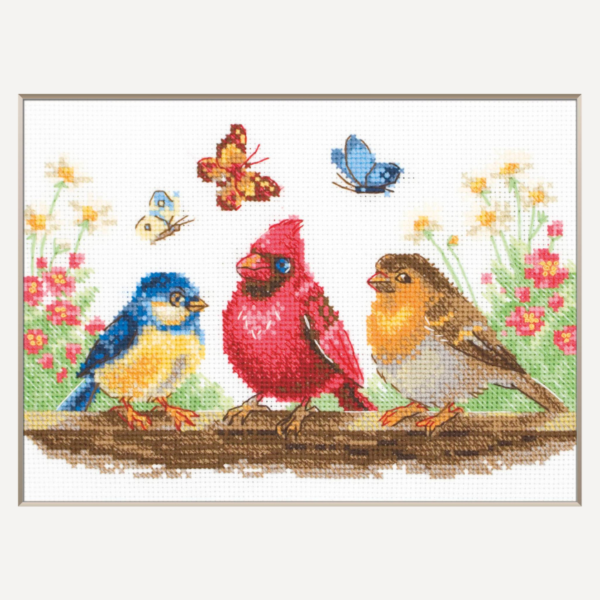 A completed cross-stitch of three colorful birds perched on a branch with butterflies and spring flowers in the background.