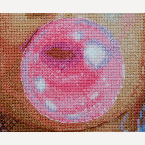 A completed cross-stitch of a girl with pastel purple hair blowing a pink bubblegum bubble, with bright blue eyes and soft blended tones.
