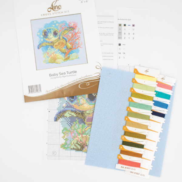 Cross-stitch kit showing a baby sea turtle underwater with coral, seashells, and a blue ocean background.