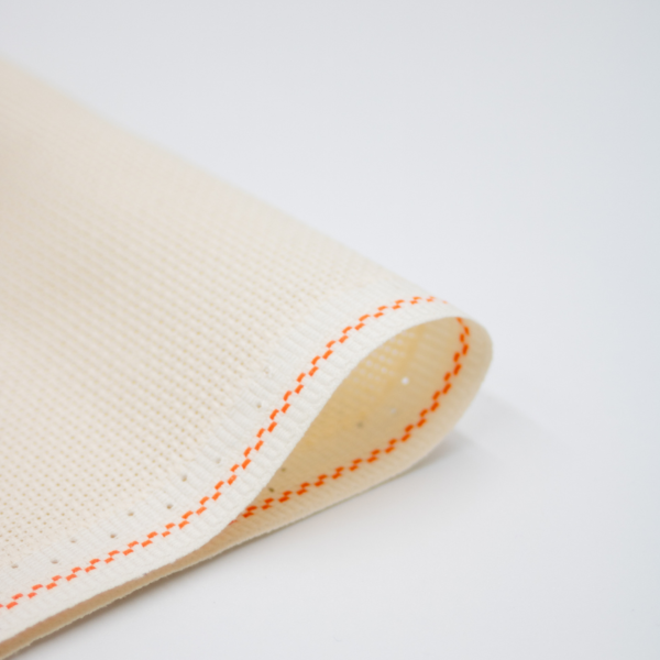 Close-up of Zweigart cream Aida fabric showcasing its intermediate evenweave grid and warm, soft cream color.