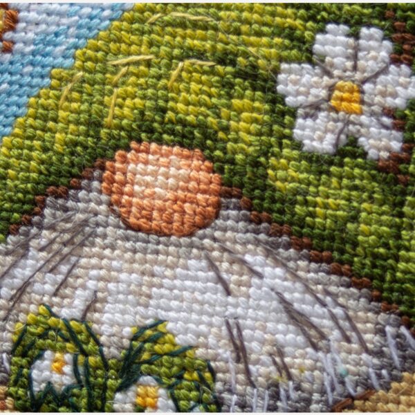 A1042 Blossom Gnome Aine Cross-Stitch Kit featuring a garden gnome in a green hat surrounded by pink flowers, foliage, and butterflies.