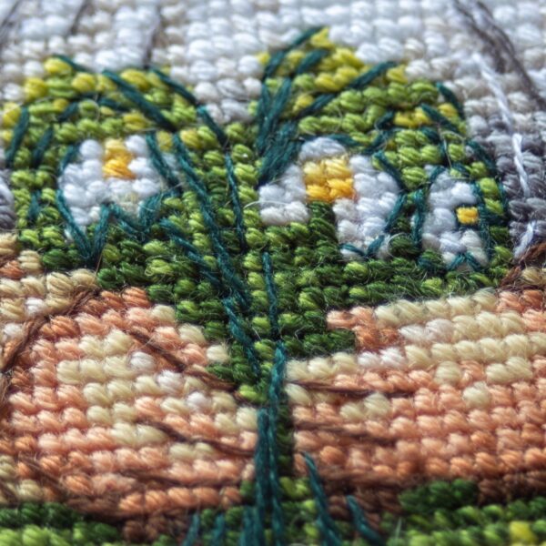 A1042 Blossom Gnome Aine Cross-Stitch Kit featuring a garden gnome in a green hat surrounded by pink flowers, foliage, and butterflies.