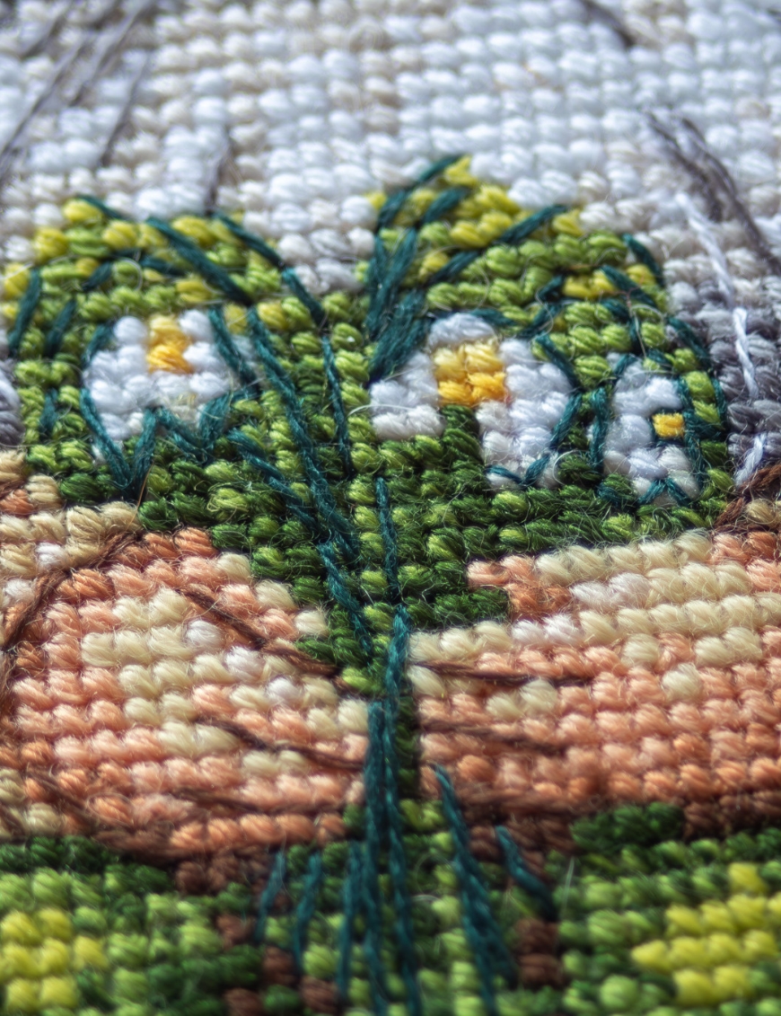A1042 Blossom Gnome Aine Cross-Stitch Kit featuring a garden gnome in a green hat surrounded by pink flowers, foliage, and butterflies.