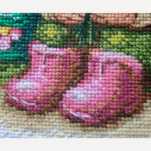 A1042 Blossom Gnome Aine Cross-Stitch Kit featuring a garden gnome in a green hat surrounded by pink flowers, foliage, and butterflies.