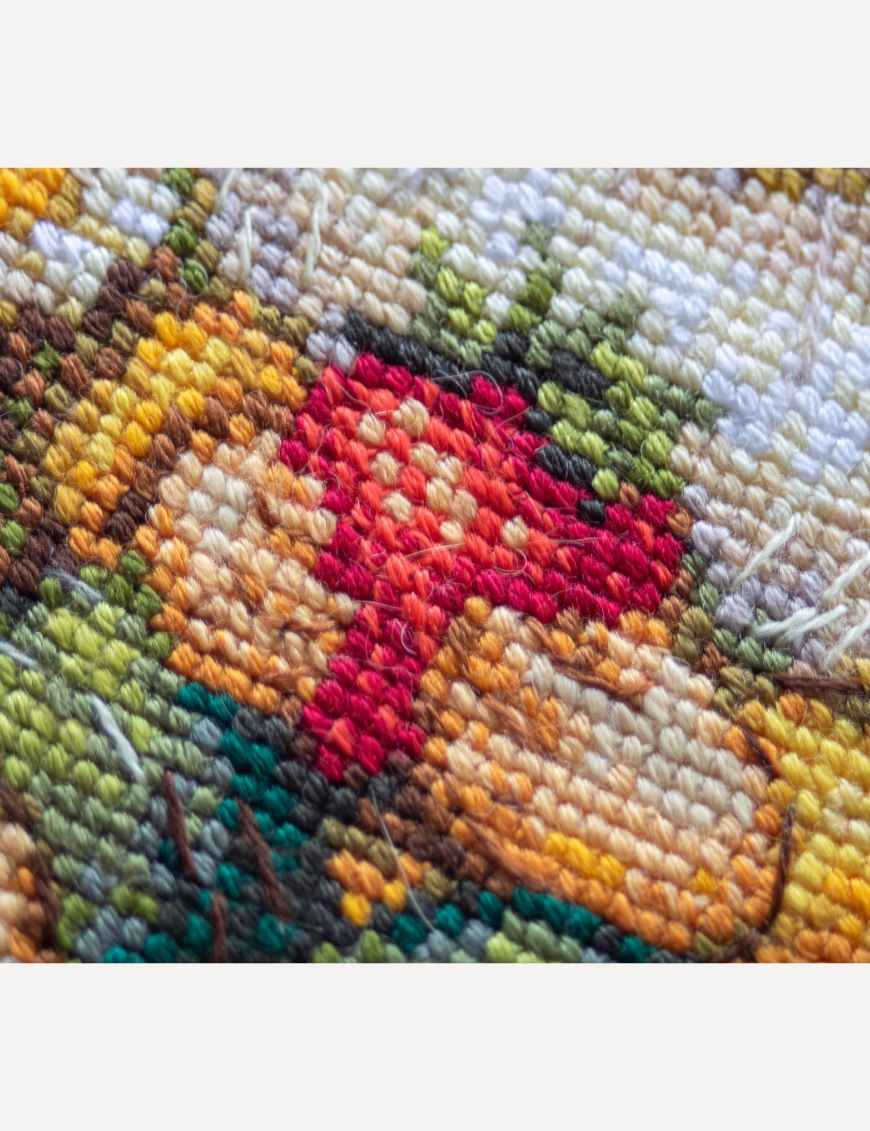 A1043 Sunshine Gnome Aine Cross-Stitch Kit featuring a garden gnome in a yellow sunflower hat surrounded by red flowers, daisies, and green foliage.