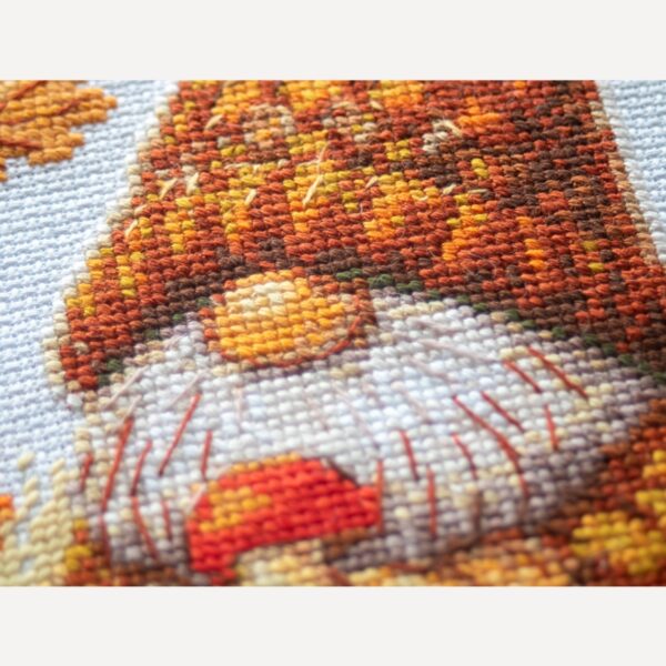A1044 Harvest Gnome Aine Cross-Stitch Kit featuring an autumn gnome with a large orange pumpkin, colorful fall leaves, and a tiny red mushroom.