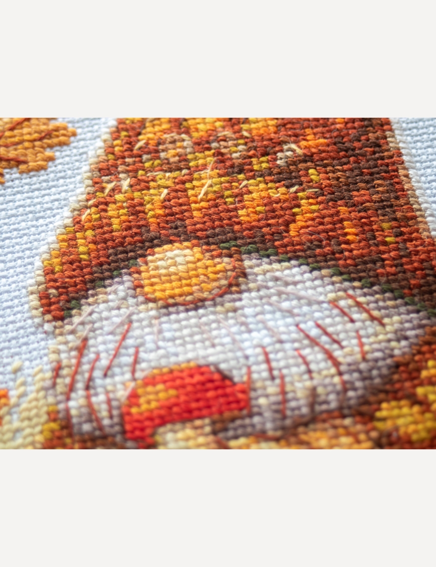 A1044 Harvest Gnome Aine Cross-Stitch Kit featuring an autumn gnome with a large orange pumpkin, colorful fall leaves, and a tiny red mushroom.