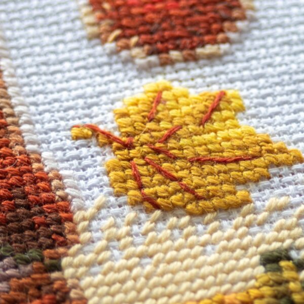 A1044 Harvest Gnome Aine Cross-Stitch Kit featuring an autumn gnome with a large orange pumpkin, colorful fall leaves, and a tiny red mushroom.
