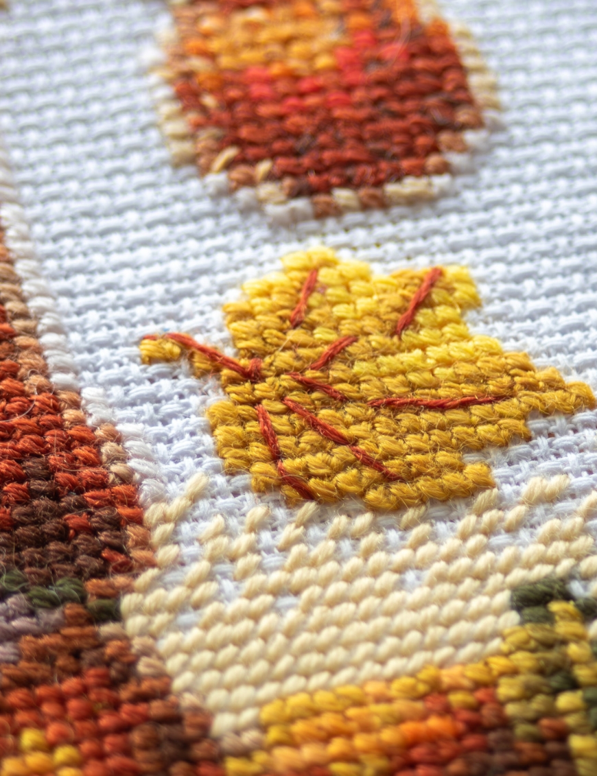 A1044 Harvest Gnome Aine Cross-Stitch Kit featuring an autumn gnome with a large orange pumpkin, colorful fall leaves, and a tiny red mushroom.