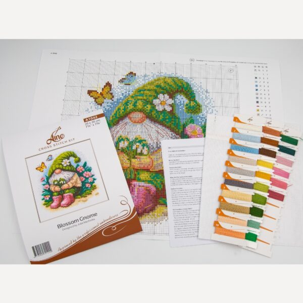 A1042 Blossom Gnome Aine Cross-Stitch Kit featuring a garden gnome in a green hat surrounded by pink flowers, foliage, and butterflies.
