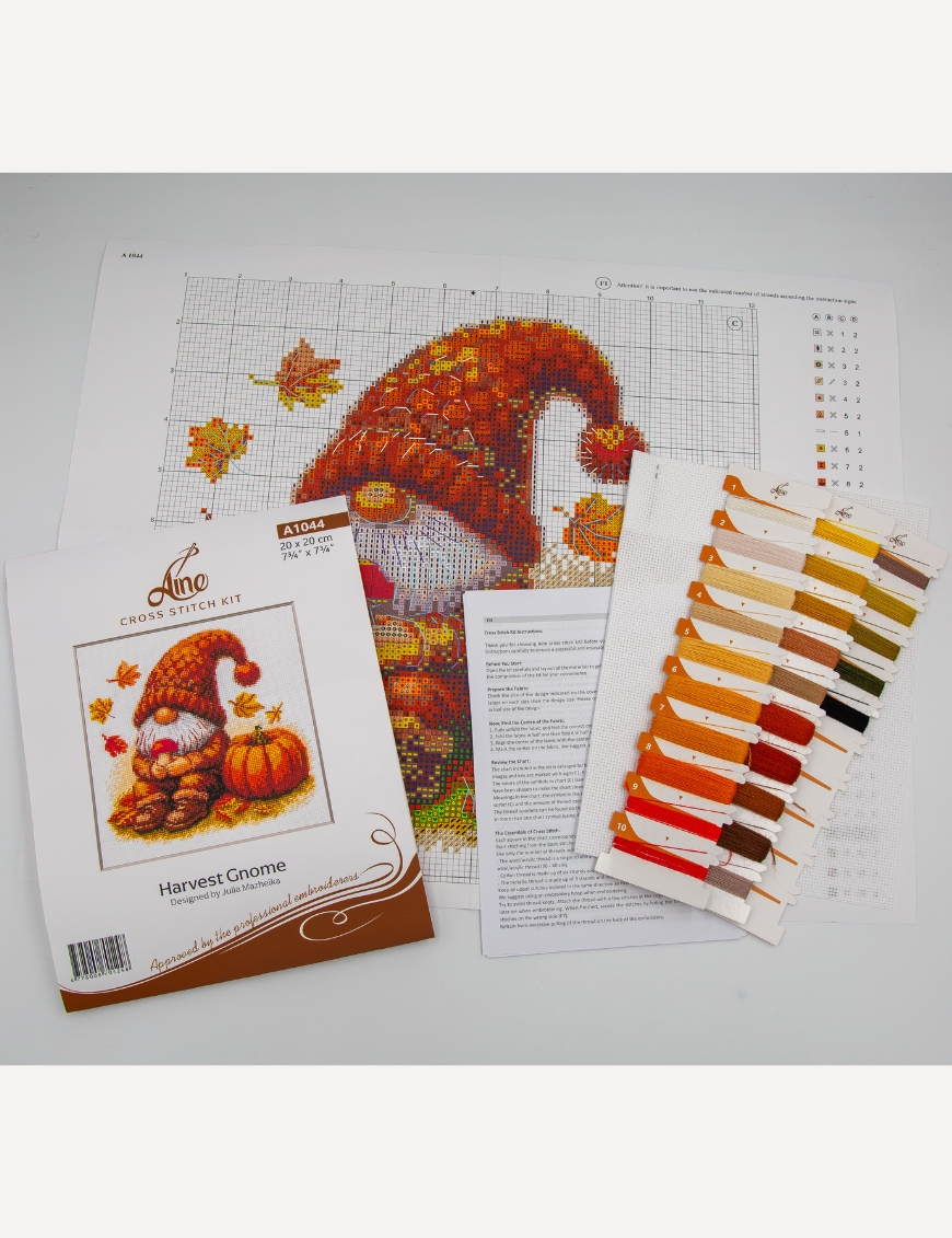 A1044 Harvest Gnome Aine Cross-Stitch Kit featuring an autumn gnome with a large orange pumpkin, colorful fall leaves, and a tiny red mushroom.