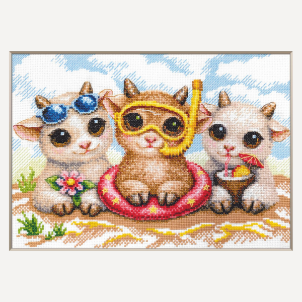 A completed cross-stitch picture of three baby goats on a beach: one wearing blue sunglasses beside a pink flower, one wearing a yellow snorkel mask and tube inside a red inflatable swim ring with yellow stars, and one drinking a tropical cocktail with a paper umbrella, set against a blue sky with white clouds.