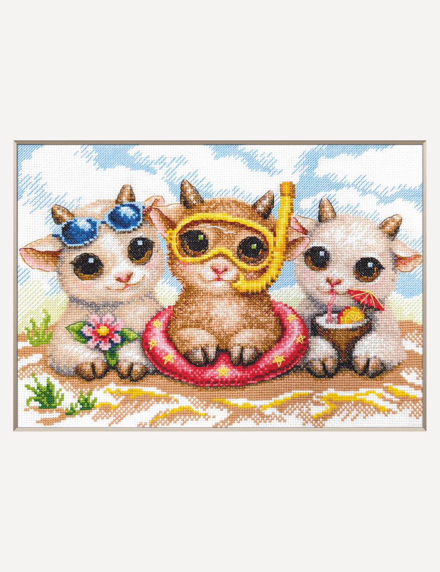 A completed cross-stitch picture of three baby goats on a beach: one wearing blue sunglasses beside a pink flower, one wearing a yellow snorkel mask and tube inside a red inflatable swim ring with yellow stars, and one drinking a tropical cocktail with a paper umbrella, set against a blue sky with white clouds.