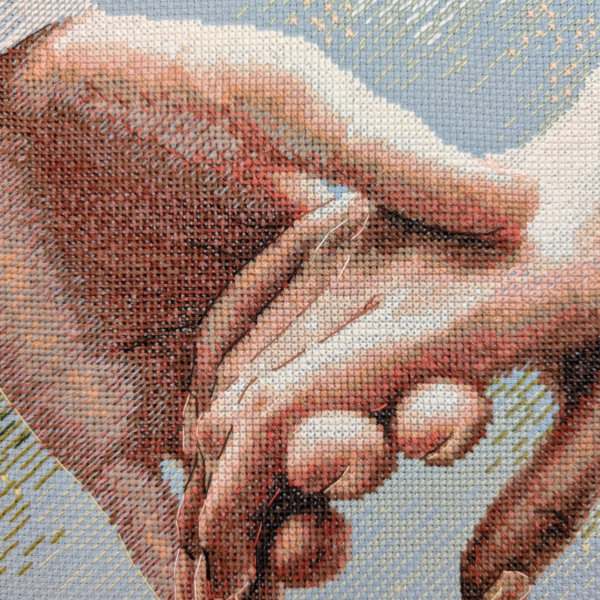 Close-up of the cross-stitched fingers of two clasped hands, with soft shading and thin backstitch lines, against a pale blue-grey background with golden sparkles.