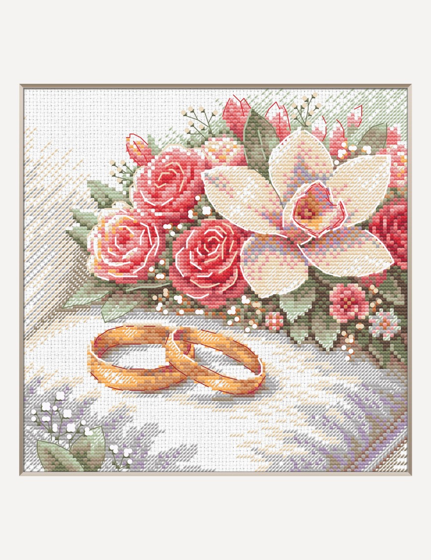 A completed cross-stitch picture of two gold wedding rings resting on soft white fabric beside a bouquet of coral-pink roses, a cream orchid and sprigs of baby’s breath with sage-green leaves.